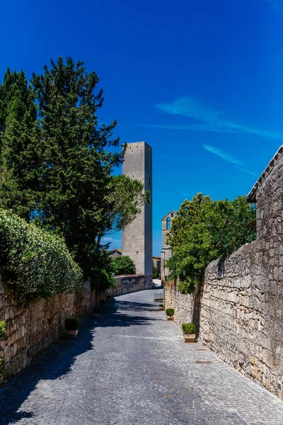 Ağaçlar ve şehrin Tarquinia, İtalya'nın eski bir kulede önde gelen duvarları olan yol