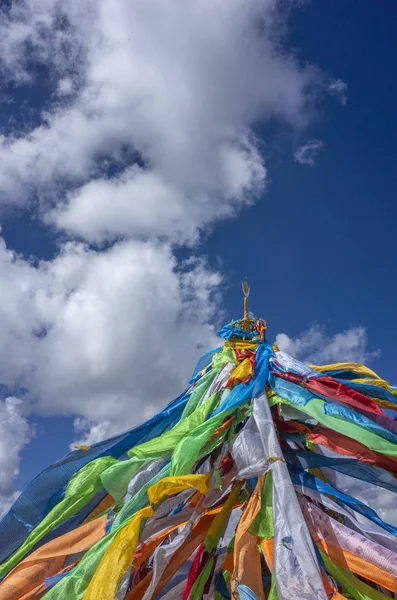 Tibetan prayer flags against sky and clouds near Qilian, Qinghai, China