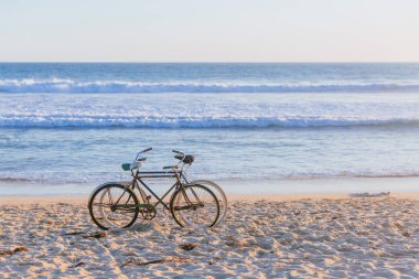 Okyanus dalgaları, Venice Beach, Los Angeles, ABD karşı sahilde iki bisiklet