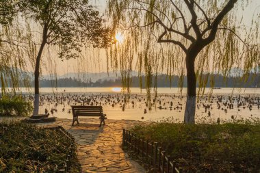 Hangzhou, Çin Batı Gölü üzerinden günbatımı bakan boş tezgah