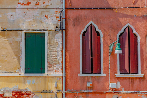 Red and yellow Venetian buildings with shutters in Venice, Italy