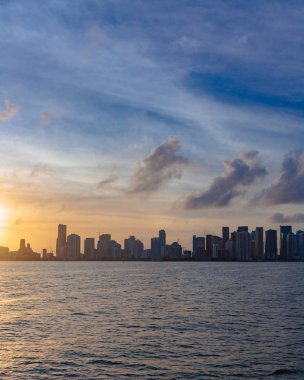 Deniz gökyüzü ve bulutlar gün batımında, Florida, ABD altında Miami'den şehrin siluetinin manzarasına
