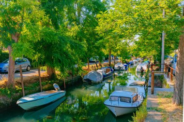 Canal ve tekneler Lido Venedik, İtalya için ağaçların altında görünümü