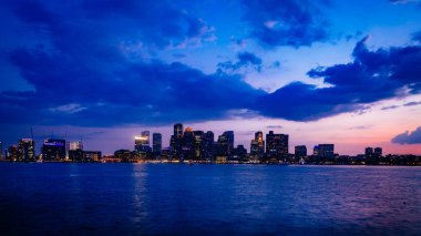 Boston Massachusetts ABD gün batımında, su üzerinde Boston kent merkezinin manzarası görünümünü