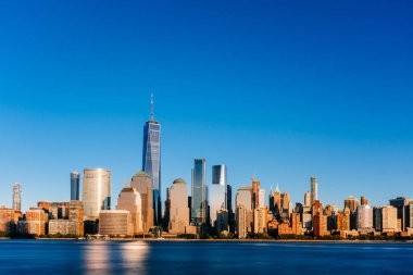 New Jersey, New York City, Amerika Birleşik Devletleri her gün batımında, mavi gökyüzü altında Manhattan Hudson Nehri üzerinde şehrin manzarası görünümünü bakıldığında