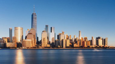 New Jersey, New York City, Amerika Birleşik Devletleri her gün batımında, mavi gökyüzü altında Manhattan Hudson Nehri üzerinde şehrin manzarası görünümünü bakıldığında