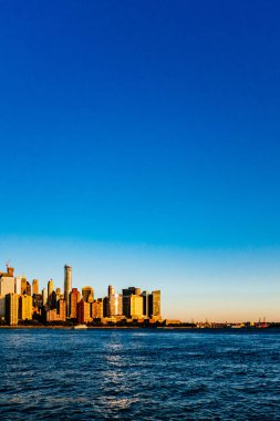 New Jersey, New York City, Amerika Birleşik Devletleri her gün batımında, mavi gökyüzü altında Manhattan Hudson Nehri üzerinde şehrin manzarası görünümünü bakıldığında