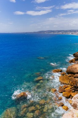 Fransa 'nın Nice kenti yakınlarındaki Fransız Rivierası' nda mavi denizin yanındaki büyük kayaların manzarası.