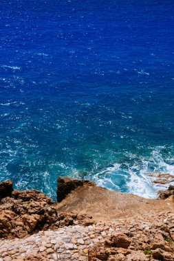 Fransa 'nın Nice kenti yakınlarındaki Fransız Rivierası' nda mavi denizin yanındaki büyük kayaların manzarası.