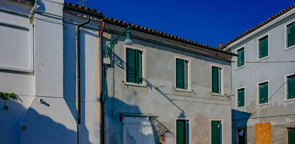 Gray houses with green windows on the island of Burano, Venice, Italy