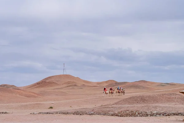 Tourists on horses traveling in the barren gobi desert viewed from the historical site of Yang Pass, in Yangguan, Gansu, China
