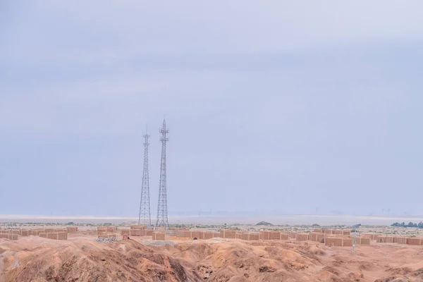 Telephone signal towers and brick houses in the middle of gobi desert near the historical site of Yang Pass, in Yangguan, Gansu, China