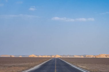 Boş iki şeritli yolun ortasında Dunhuang Yardang Ulusal Geopark, Gansu, Çin'deki gobi Çölü