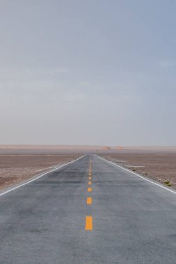 Boş iki şeritli yolun ortasında Dunhuang Yardang Ulusal Geopark, Gansu, Çin'deki gobi Çölü