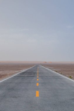 Empty two-lane road in the middle of gobi desert in Dunhuang Yardang National Geopark, Gansu, China clipart