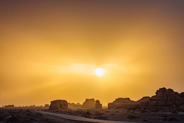 Araba yolun ortasında gobi Çölü üzerinde günbatımında Dunhuang Yardang Ulusal Geopark, Gansu, Çin'de seyahat