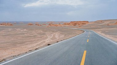 Boş iki şeritli yolun ortasında Dunhuang Yardang Ulusal Geopark, Gansu, Çin'deki gobi Çölü