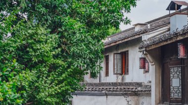Görünümü geleneksel beyaz duvar siyah çatı Çin ev tarafından yeşil ağaçlar, Hangzhou, Çin