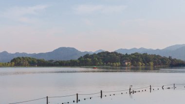 Görünüm teknelerin mesafe, Hangzhou, Çin tepelerde ile Batı Gölü üzerinde seyahat