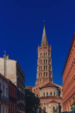 Kule, bazilika Saint-Sernin eski şehir Toulouse, Fransa mavi gökyüzünde karşı binalar arasında görünümünü
