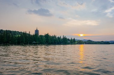 Batı Gölü ve Leifeng Pagoda görünümünü üzerinden günbatımı altında tepelerde Hangzhou, Çin