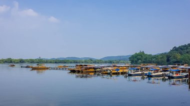 Dock üzerinde West Lake, sakin su Hills mesafe, Hangzhou, Çin'de tekneler