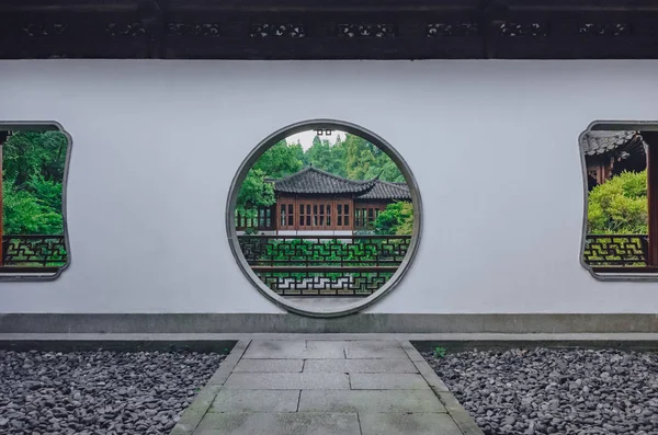 Geleneksel Çince binada, Hangzhou, Çin Batı Gölü yakınındaki bir Çin bahçe manzaralı bir ay geçide giden yol