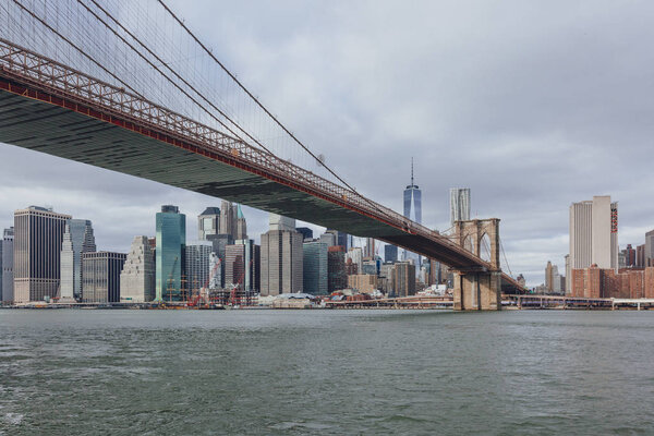 Manhattan skyline viewed from Brooklyn with Brooklyn bridge over East River, in New York City, USA