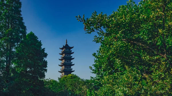 中国乌镇老城区蓝天下树木之间的莲花塔景观 — 图库照片
