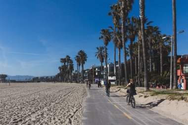 Venedik plajında plaj yanında bisiklet sürme Locals