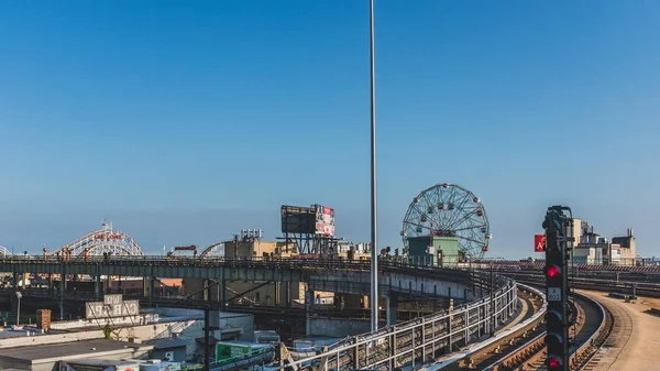 View of metro train tracks and ferris wheel and roller coasters — Stock Photo, Image