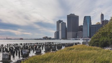 East River 'da Manhattan 'ın merkezindeki gökdelenler, Brooklyn Bridge Park 'tan, Brooklyn 'de, New York 'ta, ABD 'de inceledi.