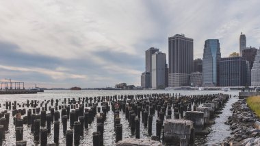 East River 'da Manhattan 'ın merkezindeki gökdelenler, Brooklyn Bridge Park 'tan, Brooklyn 'de, New York 'ta, ABD 'de inceledi.