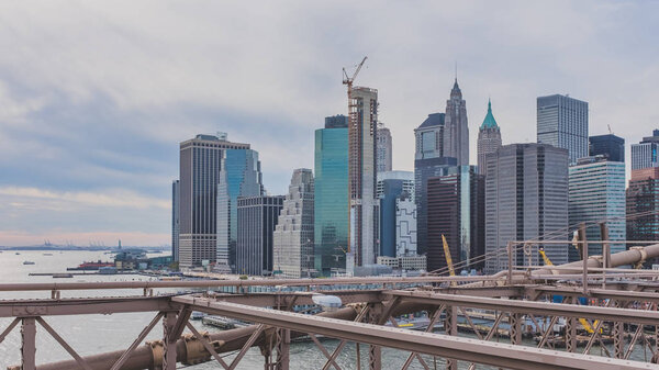 View of buildings and skyscrapers of downtown Manhattan from Brooklyn Bridge, in New York, USA