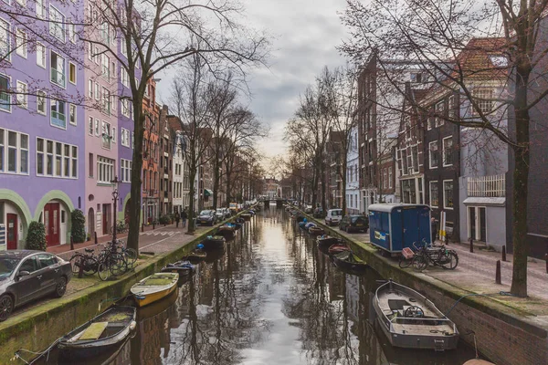 Канал с лодками и зданиями в центре Амстердама — стоковое фото