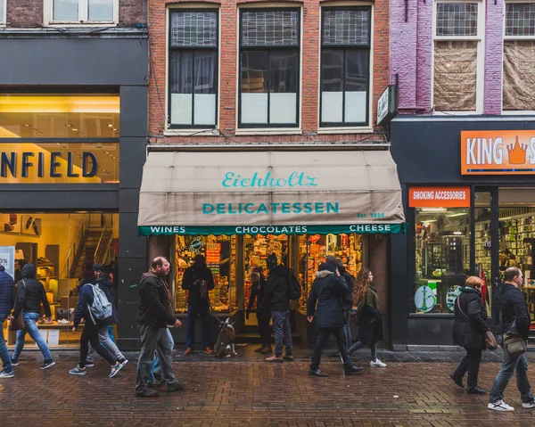 शहर एम्स्टर्डम में दुकानों के पास चलने वाले स्थानीय लोग — स्टॉक फ़ोटो, इमेज