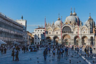 Gün batımında St. Mark Meydanı ve Bazilika'yı ziyaret eden turistler