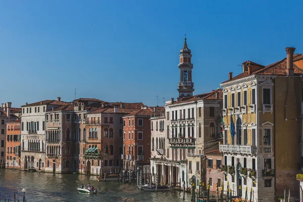 Лодка, путешествующая по Гранд-каналу вдоль венецианских зданий и башни — стоковое фото
