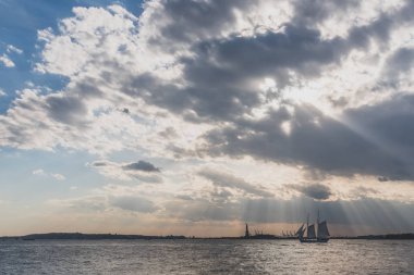 New York Cit'te Gün Batımında Özgürlük Heykeli'nin yanından geçen tekne