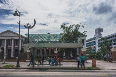 Locals waiting for buses at a bus stop in San Juan clipart