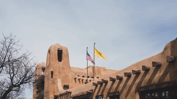 Flags over pueblo style building in Santa Fe, NM, USA