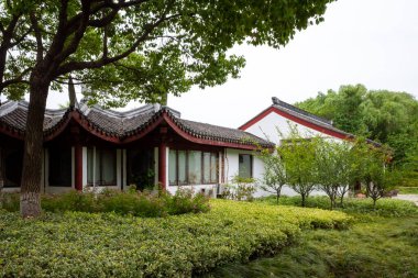 Çin 'in Jiaxing kentindeki Güney Gölü manzaralı alanındaki ağaçlar arasında geleneksel Çin mimarisi