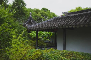 Çin 'in Jiaxing kentindeki Güney Gölü manzaralı alanındaki ağaçlar arasında geleneksel Çin mimarisi