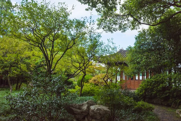 中国杭州の西湖風景区の中国庭園の木の間の伝統的な建築 — ストック写真