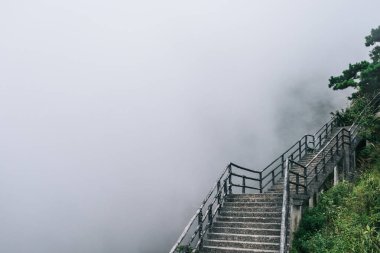 Jiangxi, Çin 'deki Wugong Dağı' nın tepesinde sisle kaplı bir patika ve manzara.