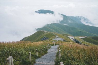 Jiangxi, Çin 'deki Wugong Dağı' nda bulutlarla kaplı bir dağ sırtında dönen patika.