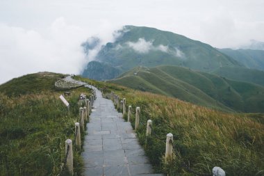 Jiangxi, Çin 'deki Wugong Dağı' nın tepesinde bulutlarla kaplı dağ manzarasına giden patika.