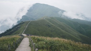 Jiangxi, Çin 'deki Wugong Dağı' nda bulutlarla kaplı bir dağ sırtında dönen patika.