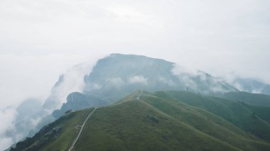 Jiangxi, Çin 'deki Wugong Dağı' nda bulutlarla kaplı bir dağ sırtında dönen patika.