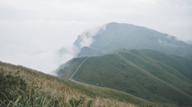Jiangxi, Çin 'deki Wugong Dağı' nda bulutlarla kaplı bir dağ sırtında dönen patika.
